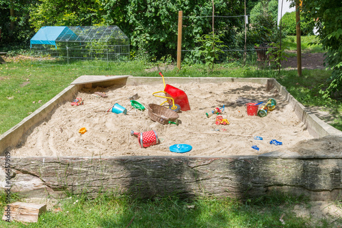 Grosser Sandkasten Mit Kinderspielzeug In Einem Garten Buy This