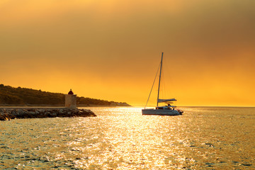 Wall Mural - Yacht getting ready to be moored in the harbor of a small town Postira - Croatia, island Brac