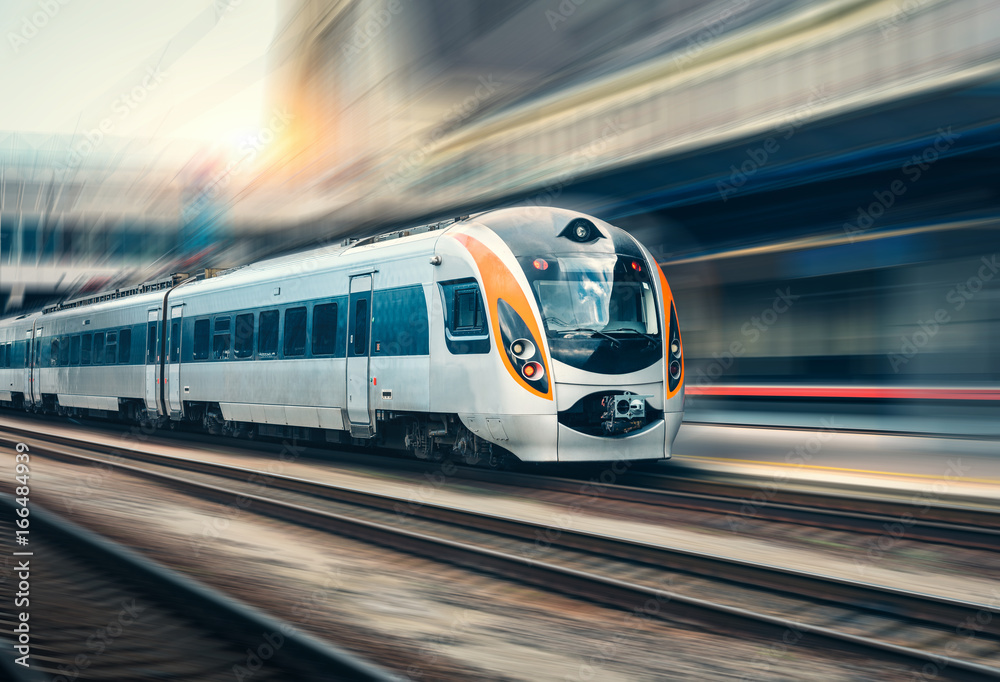 High speed train in motion at the railway station at sunset - obrazy, fototapety, plakaty 
