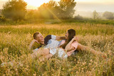 Fototapeta Kuchnia - happy young couple lying on the grass on the field