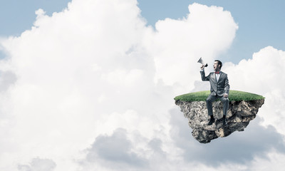 Businessman floating on island in sky and announcing something i