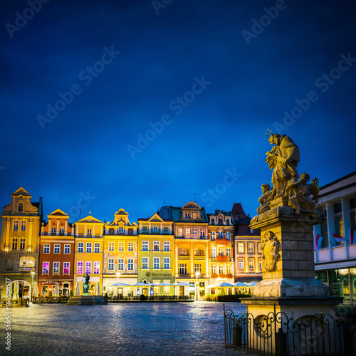 Zdjęcie XXL Nocne zdjęcie poznańskiej Starówki z figurą św. Jana Nepomucena i licznymi iluminowanymi kamienicami.