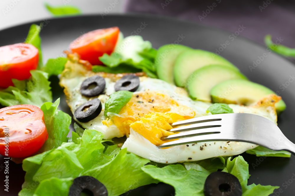 Plate with over hard fried egg and vegetables, closeup