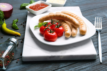 Sticker - Plate with roasted sausages and tomatoes on wooden background