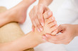 Therapist giving relaxing thai reflexology foot massage to a woman in spa