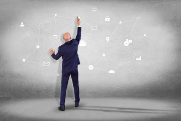 Poster - businessman in front of a wall with a business network connection displayed on a futuristic interfac