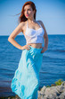 © T.Den_Team - Redhead slim woman wearing tender pastel dress posing on a sea, fashionable woman walking on the shore. Young girl on a beach in a white tones. Pastel colors. The concept of femininity ad harmony