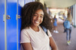 © Monkey Business - Portrait of black teenage girl by lockers in school corridor