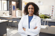 © Monkey Business - Female teacher in lab coat smiling in school science room