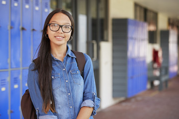 Happy Asian teenage girl smiling in high school corridor