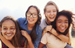 Leinwandbild Motiv Four teenage girls having fun piggybacking outdoors