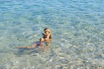 Child little girl wearing diving goggles in the sea. Portrait of a cute girl wearing a goggles for diving background of the sea