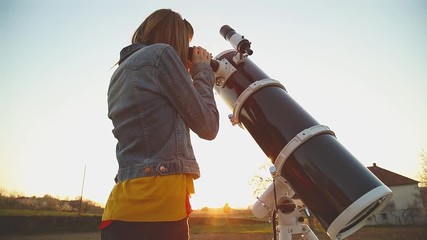 Wall Mural - girl looking at the stars with telescope beside her.