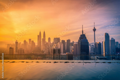 Cityscape of Kuala lumpur city skyline with swimming pool on the roof top of hotel at sunrise in Malaysia Poster