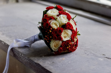 Wedding flowers, a bouquet of red and cream roses with red berries. The bride's bouquet