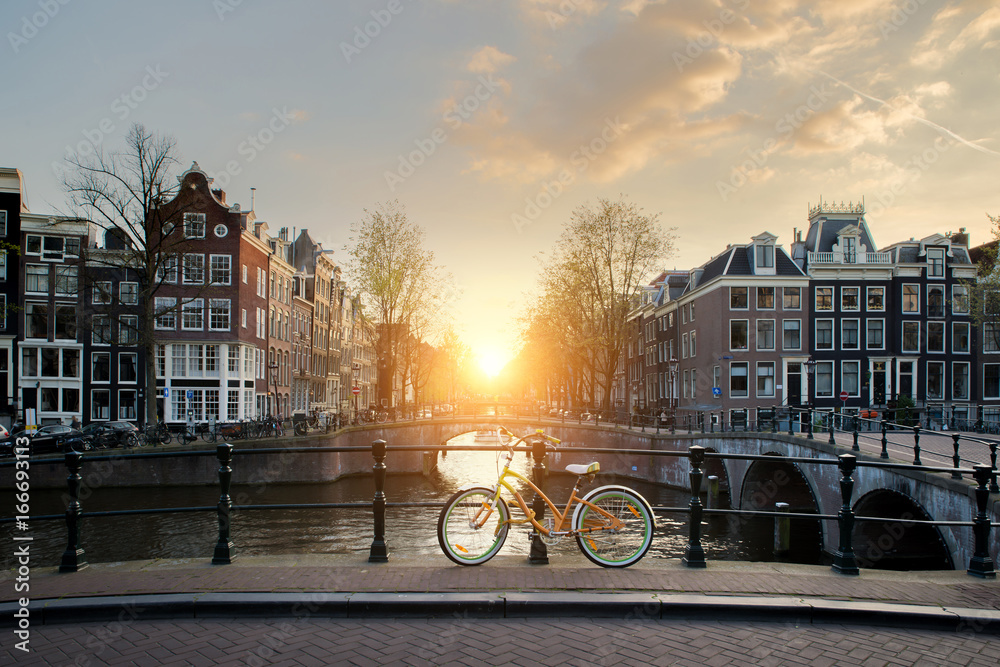 Bicycles lining a bridge over the canals of Amsterdam, Netherlands. Bicycle is major form of transportation in Amsterdam, Netherlands. - obrazy, fototapety, plakaty 