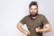 © khosrork - Portrait of funny crazy bearded man with dark green t shirt against light gray background. studio shot.  .