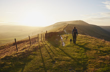 Male Walking His Dog On Rushup Edge At Sunset. Derbyshire, UK.