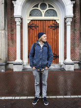 Young Man With Beanie Standing In Front Of The Door Of A Church In Amsterdam