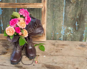 Wall Mural - Fresh pink and orange roses in vintage brown boots