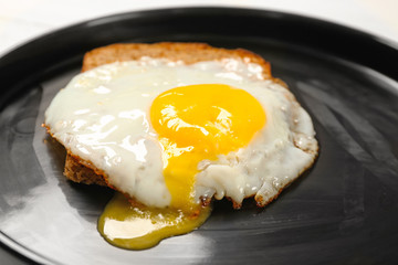 Wall Mural - Delicious over easy egg with bread slice on plate, closeup