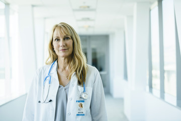 Wall Mural - Portrait of confident, happy female doctor in hospital hallway