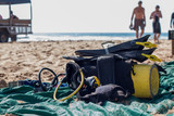 Old and worn scuba diving gear laying on the beach in the sun.