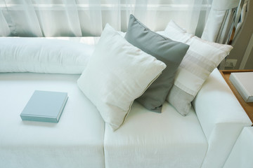 Wall Mural - Pillows and books setting on white sofa in living room