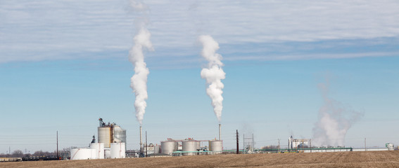 Smoke billowing out of Factory with smog layer above