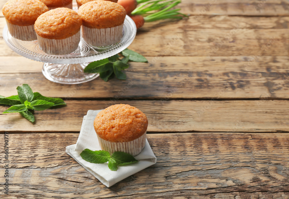 Composition with delicious carrot muffins on wooden table