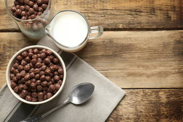 Wall Mural - Chocolate corn balls in bowl and jug with milk on wooden table