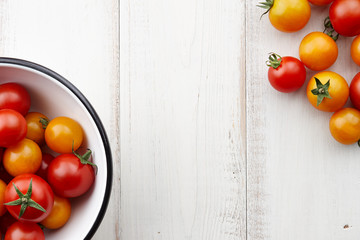 Wall Mural - Bright red and yellow tomatoes on white wooden table, top view