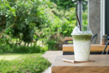 Ice green tea latte on the table in the garden