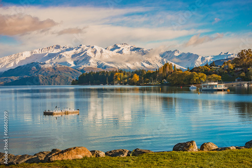Fototapeta Rano śnieg nad jeziorem Wanaka, wyspa południowa, Nowa Zelandia z widokiem na góry śniegu, kolorowe drzewa jesienią, jeziora i błękitne niebo