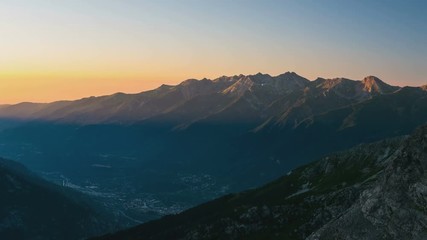 Wall Mural - Mountain ridges and peaks illuminated by the sunrise, time lapse. The Alps in summer, Susa Valley, Torino Province, Italy. Sliding version.