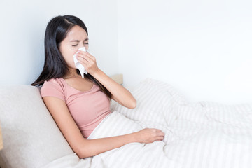 Wall Mural - Sick Woman sneezing on bed