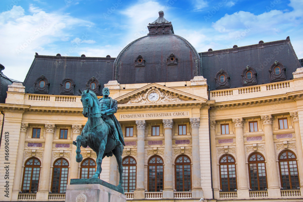 Beautiful view of the building of the Central University Library with equestrian monument to King Karol I in front of him in Bucharest, Romania - obrazy, fototapety, plakaty 