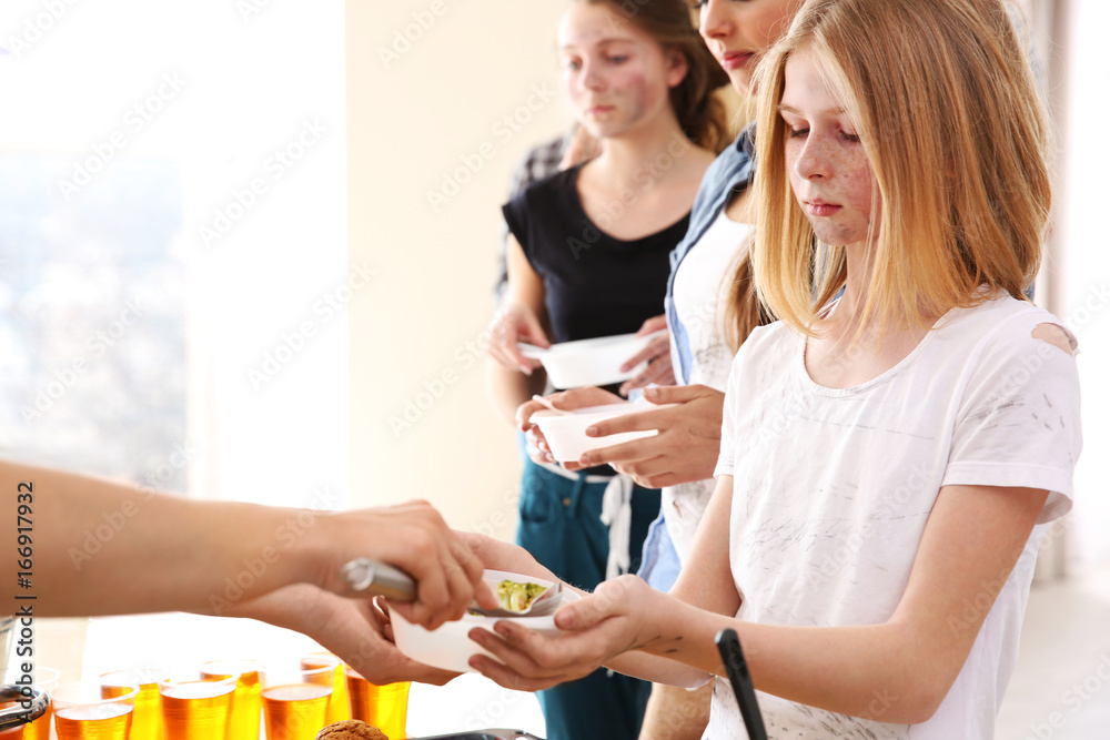 Volunteer giving food to poor people. Poverty concept