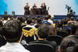 © THANANIT - Speakers on the stage with Rear view of Audience in the conference hall or seminar meeting, business and education about investment concept