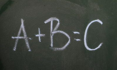 Mathematical equation with letters on chalkboard, blackboard texture