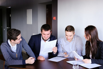 Four colleagues of man and woman gather for meeting at office of