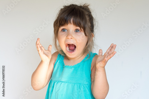 Fotografia, Obraz Surprised Cute child holding hands in surprised gesture, keeping mouth wide open