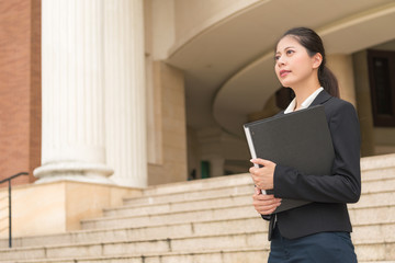 smiling female lawyer holding legal case file