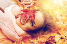 Beautiful Happy Woman Lying On Autumn Leaves