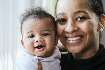 Close up portrait of a African American woman holding a baby girl