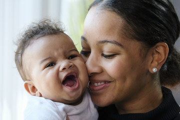 close up portrait of a african american woman holding a baby girl
