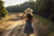 Girl walking on a countryside rural road in the middle of nature in summer