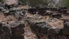 Slow Pan Over Piles Of Black Rubble From Ancient Town In Israel 