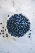 Fresh Organic Blueberries In A White Bowl On White Marble Table