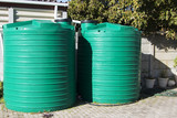 Fototapeta  - water catchment plastic tanks setup backyard pipes